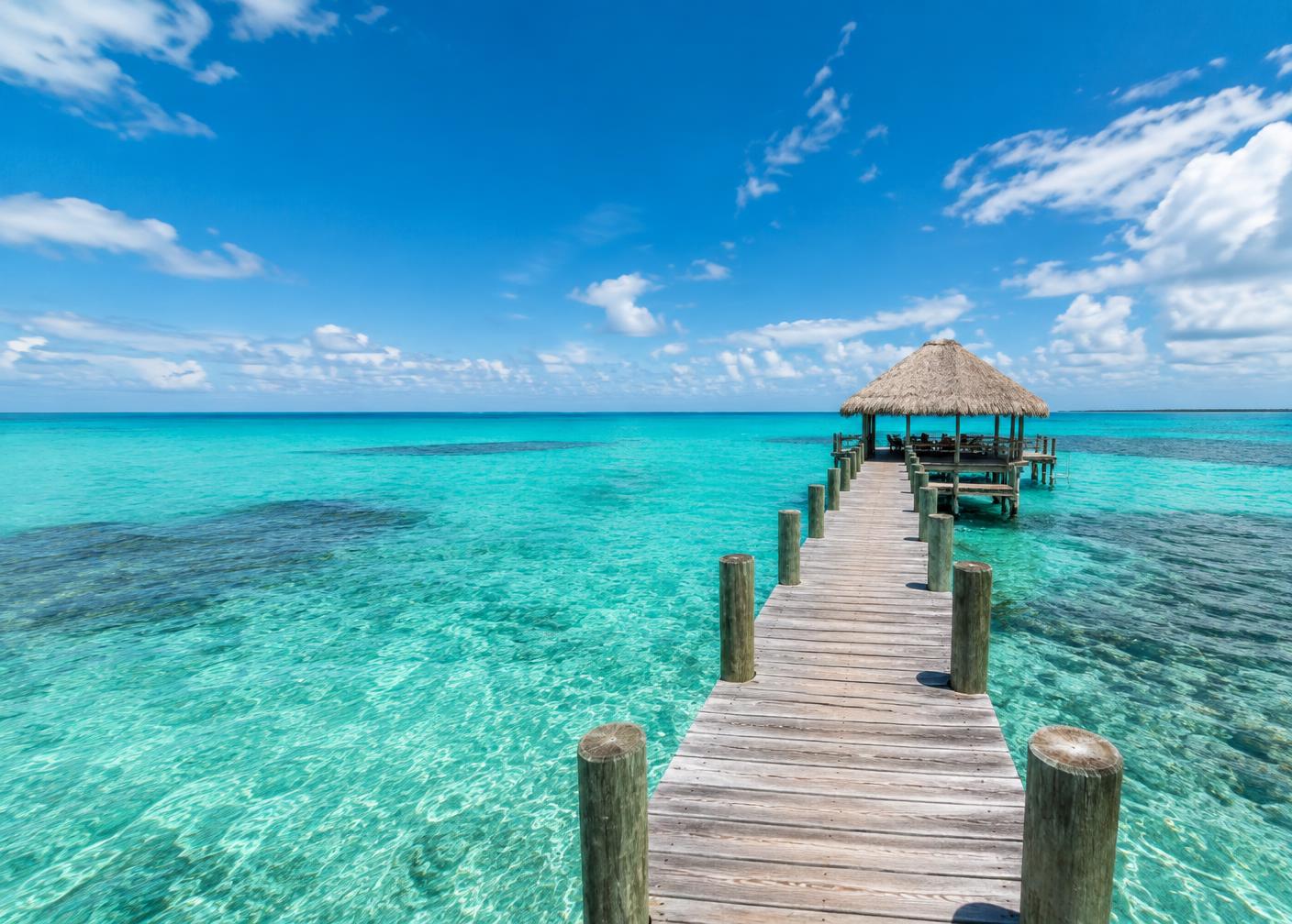 A wooden dock over turquoise water in Ambergris Caye, Belize